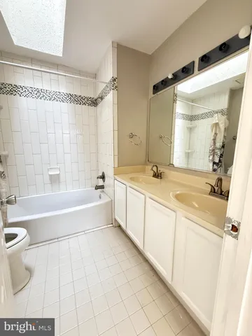 a spacious bathroom with a tub a sink and a mirror