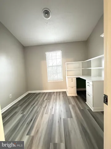 an empty room with windows and fireplace