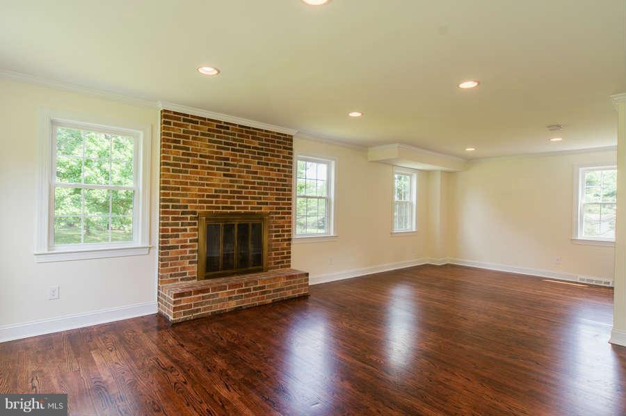 13029 Fork Road Baldwin, MD 21013 - Photo 3 of 30 an empty room with wooden floor fireplace and windows