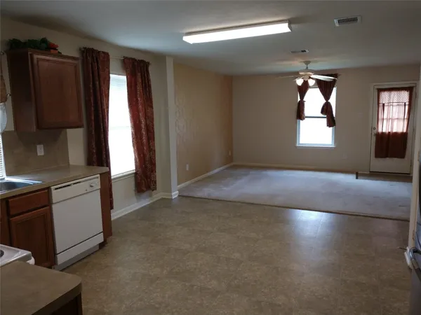 an empty room with windows cabinet and fire place