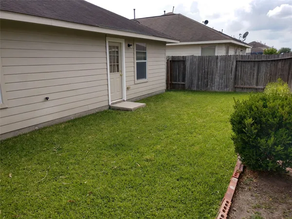 a view of a house with a yard and wooden fence