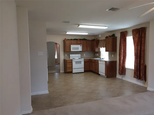 a kitchen with stainless steel appliances granite countertop a refrigerator and a stove top oven