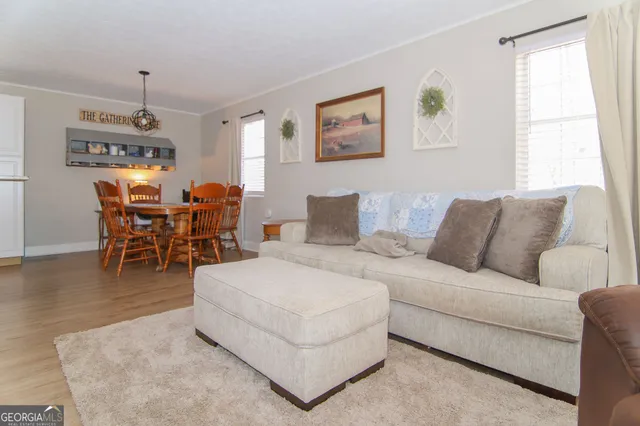 a living room with furniture a dining table and a window