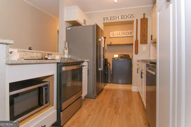 a kitchen with granite countertop a refrigerator and a stove