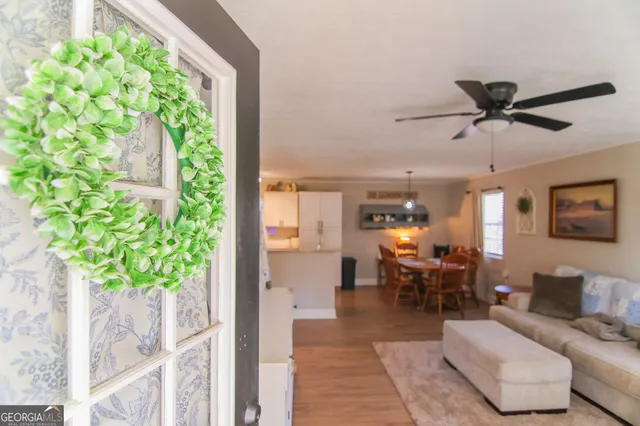 a living room with patio furniture and a potted plant