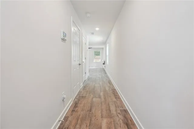 a view of a hallway with wooden floor