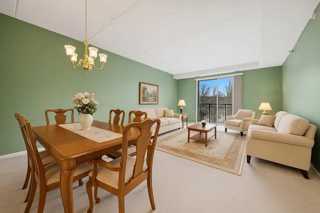 a dining room with furniture a chandelier and window