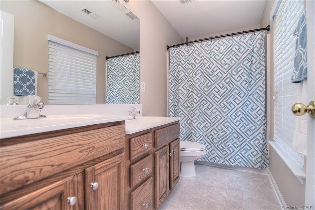 13219 Meadowmere Road Huntersville, NC 28078 - Photo 21 of 28 a bathroom with a sink a toilet and shower curtain