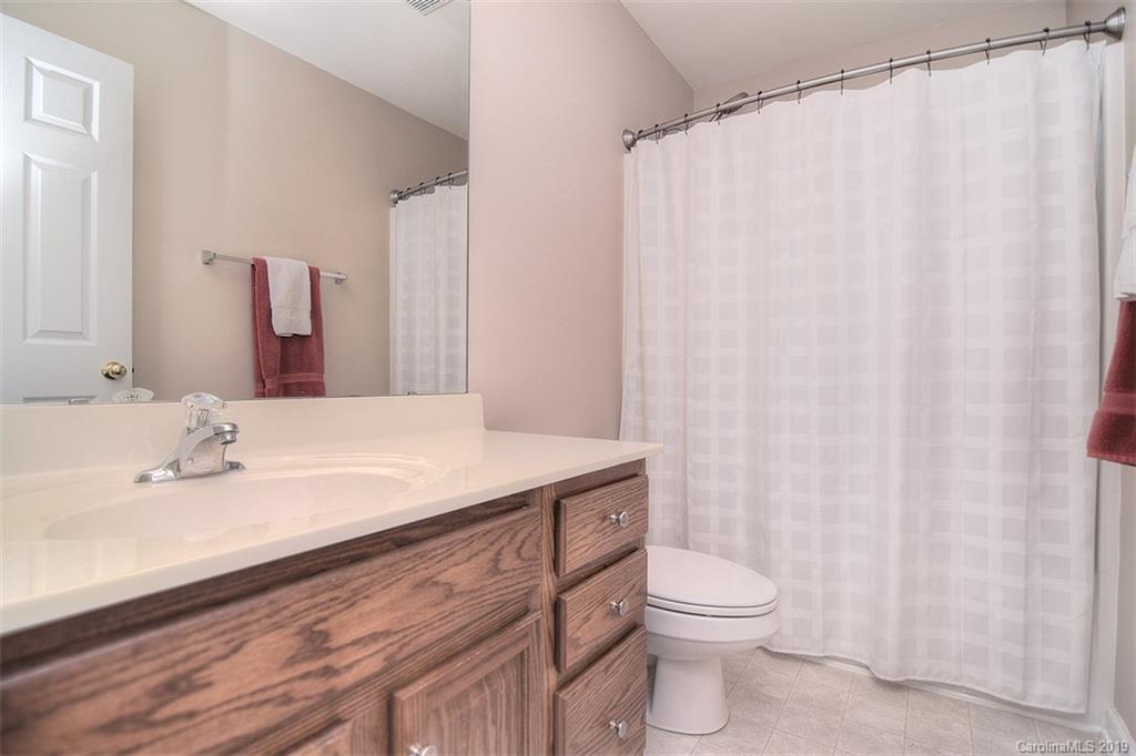 13219 Meadowmere Road Huntersville, NC 28078 - Photo 23 of 28 a bathroom with a sink a toilet and shower curtain