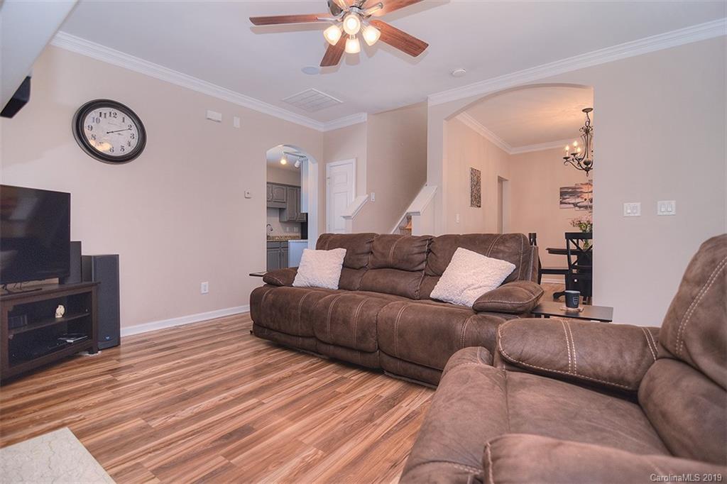 13219 Meadowmere Road Huntersville, NC 28078 - Photo 7 of 28 a living room with furniture a clock and a flat screen tv