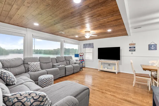 a bedroom with a large bed a flat tv screen and dresser