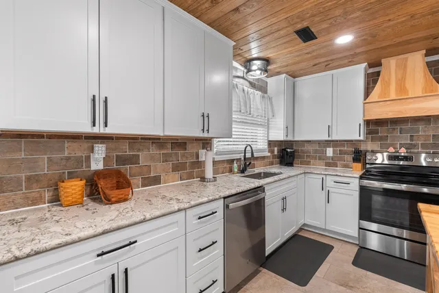 a view of an empty room with wooden floor and a fireplace