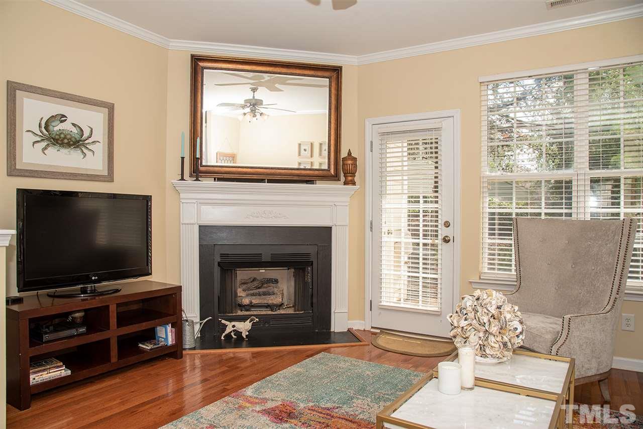8272 City Loft Court Raleigh, NC 27613 - Photo 11 of 26 a living room with furniture a flat screen tv and a fireplace