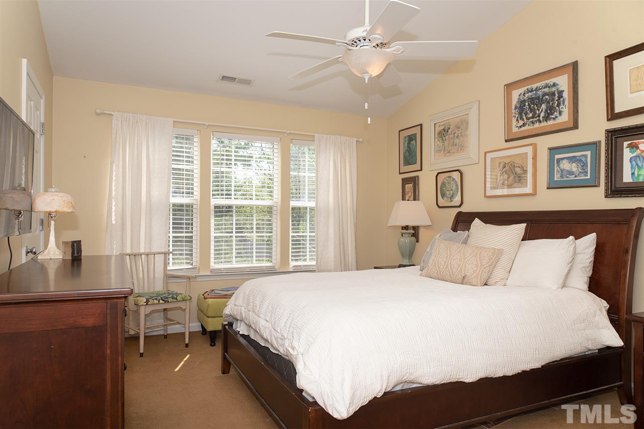 8272 City Loft Court Raleigh, NC 27613 - Photo 15 of 26 a bedroom with a large bed and a chandelier