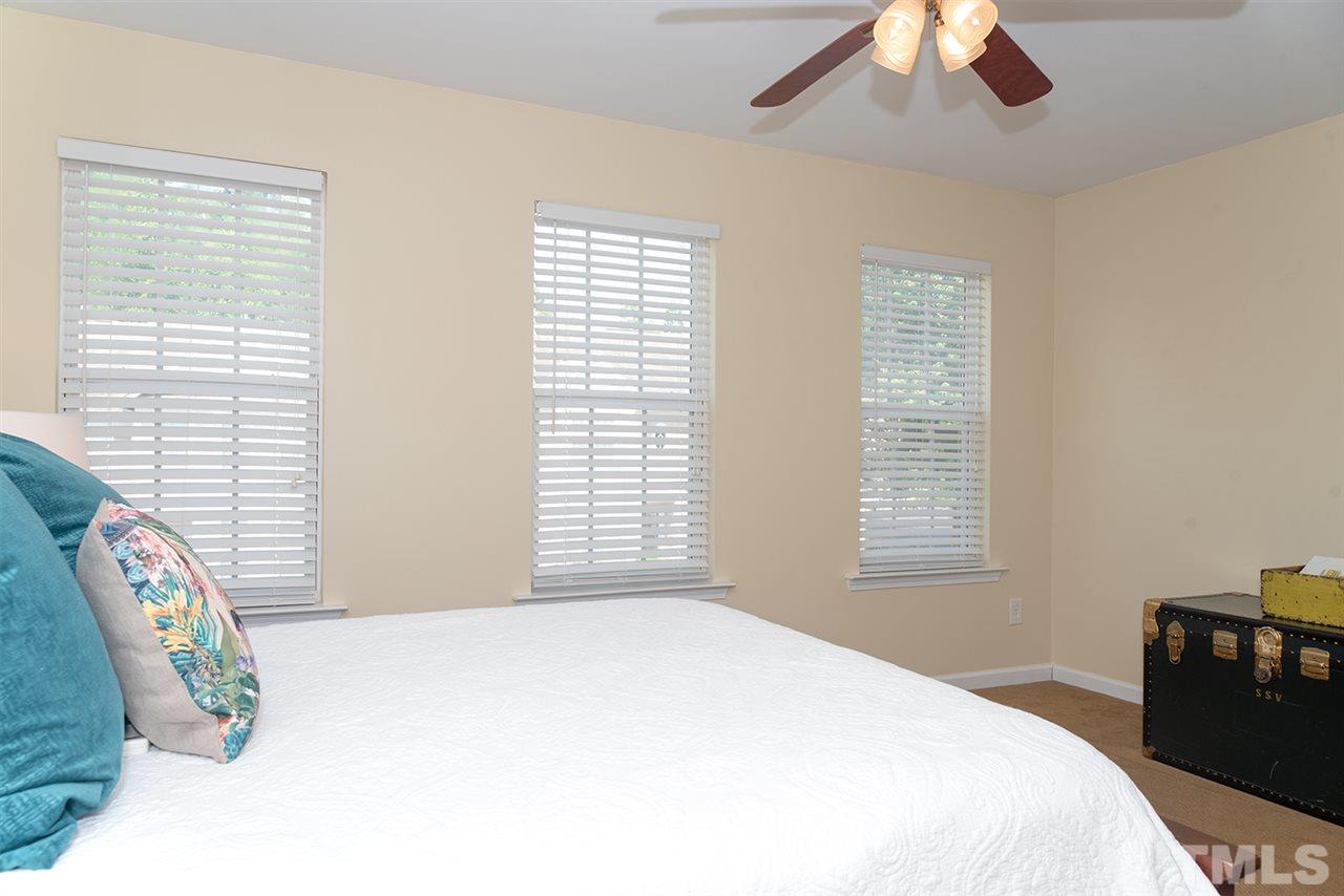 8272 City Loft Court Raleigh, NC 27613 - Photo 22 of 26 a bedroom with a bed next to a window and a chandelier