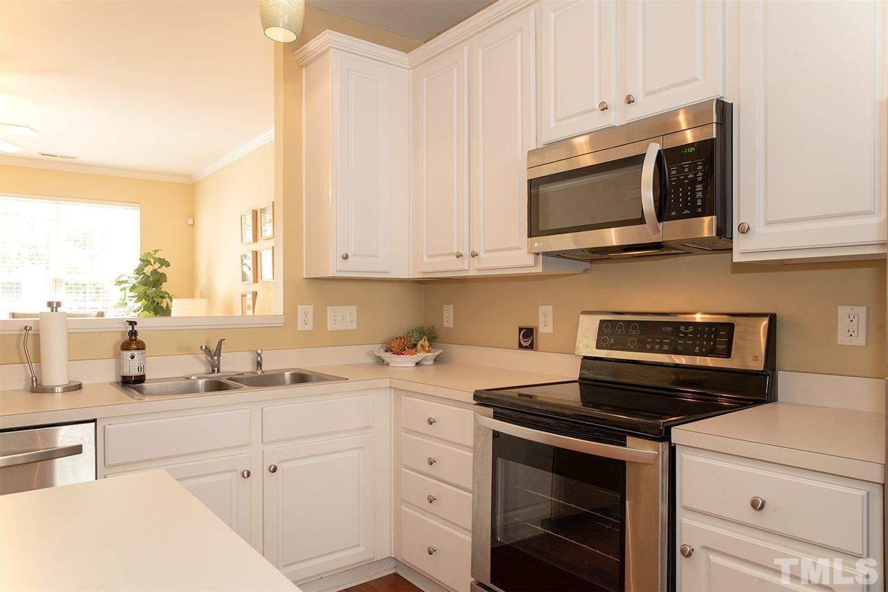 8272 City Loft Court Raleigh, NC 27613 - Photo 10 of 26 a kitchen with stainless steel appliances white cabinets and a stove a oven with white countertops