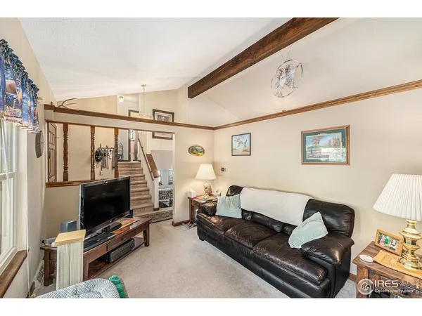 a living room with furniture a flat screen tv and a floor to ceiling window