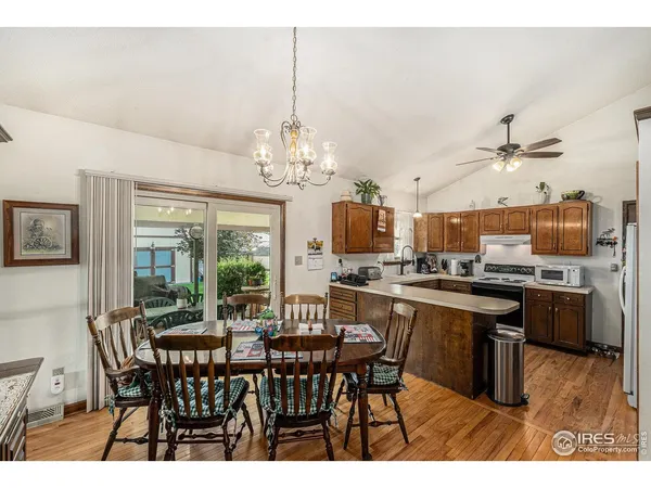a view of a dining room with furniture a chandelier and wooden floor
