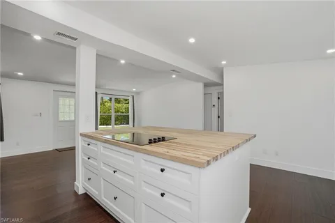 a view of a room with wooden floor and a ceiling fan