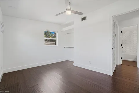 an empty room with wooden floor and a window