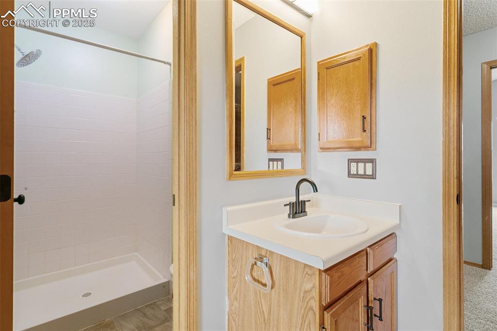 3457 Queen Anne Way Colorado Springs, CO 80917 - Photo 14 of 25 Bathroom featuring vanity and tiled shower
