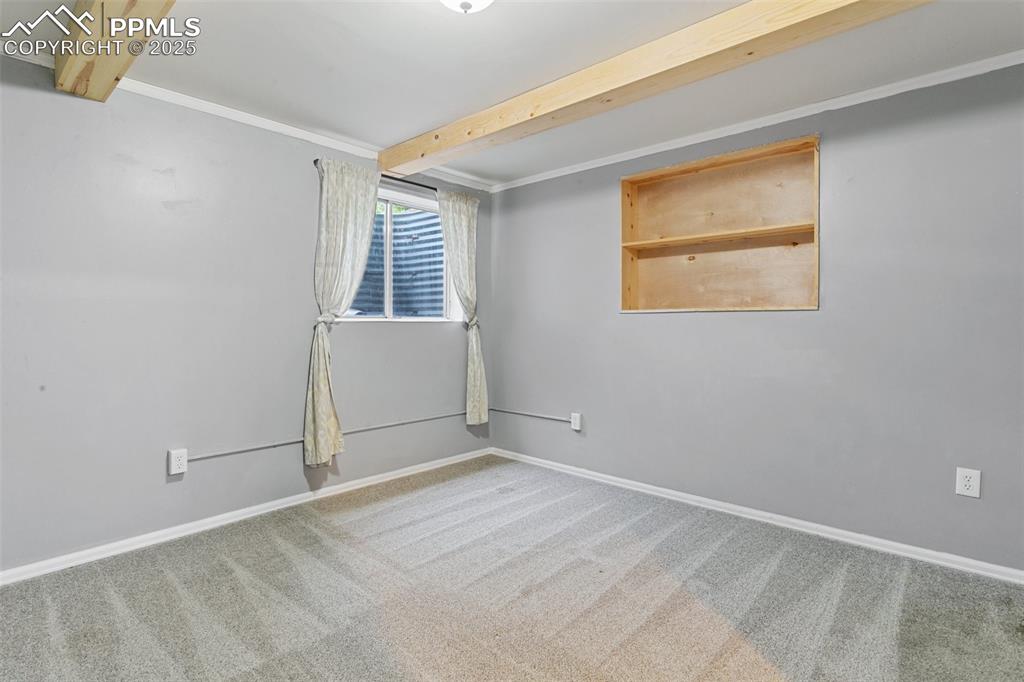 3457 Queen Anne Way Colorado Springs, CO 80917 - Photo 21 of 25 Carpeted spare room with beamed ceiling and baseboards