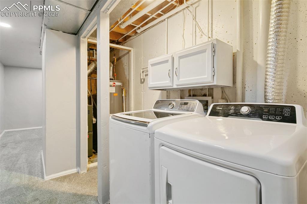 3457 Queen Anne Way Colorado Springs, CO 80917 - Photo 24 of 25 Laundry room with washer and clothes dryer, cabinet space, and light colored carpet