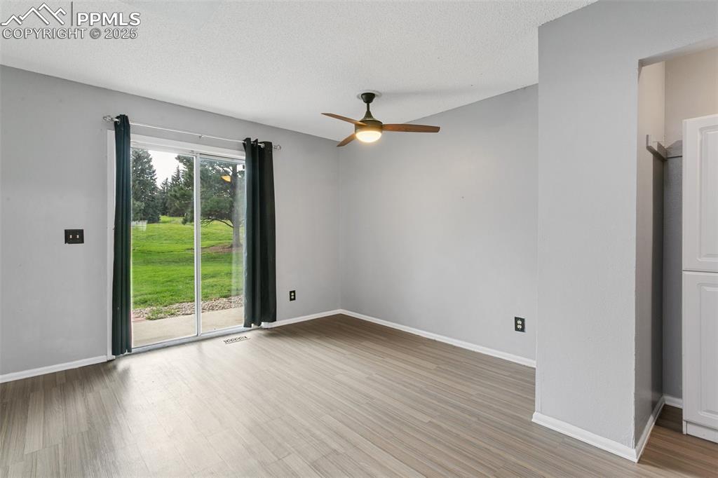 3457 Queen Anne Way Colorado Springs, CO 80917 - Photo 8 of 25 Empty room with a ceiling fan, wood finished floors, and a textured ceiling