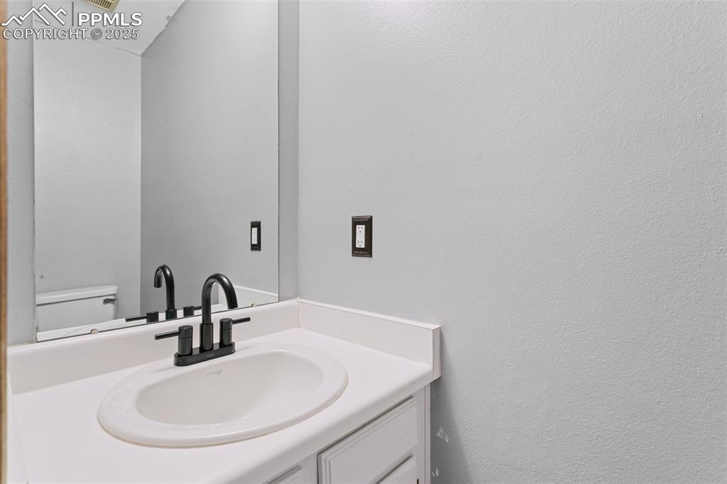 3457 Queen Anne Way Colorado Springs, CO 80917 - Photo 10 of 25 Half bathroom with vanity and toilet