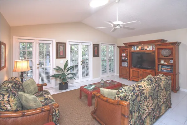 a living room with furniture and large windows