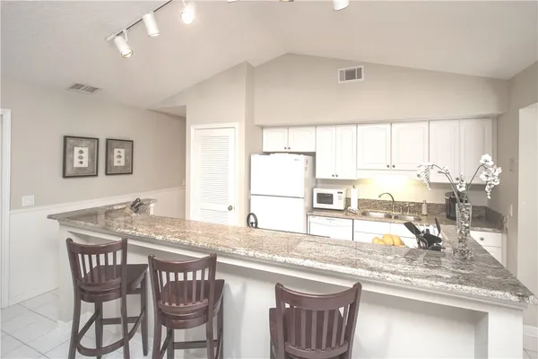 a kitchen with granite countertop lots of counter top space and windows