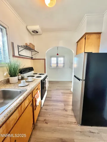 a view of a kitchen with a sink and wooden floor