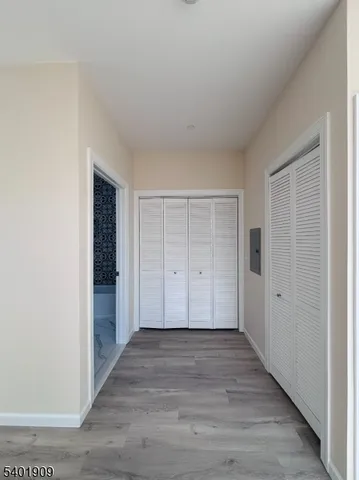 a view of an empty room with closet and wooden floor