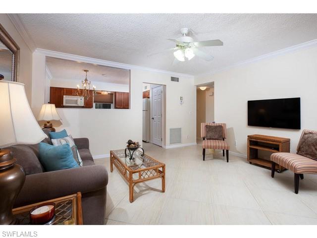 940 3rd Street South, Unit 104 Naples, FL 34102 - Photo 3 of 8 a living room with furniture and a flat screen tv