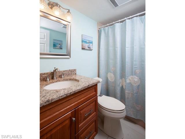 940 3rd Street South, Unit 104 Naples, FL 34102 - Photo 7 of 8 a bathroom with a granite countertop sink a toilet and shower
