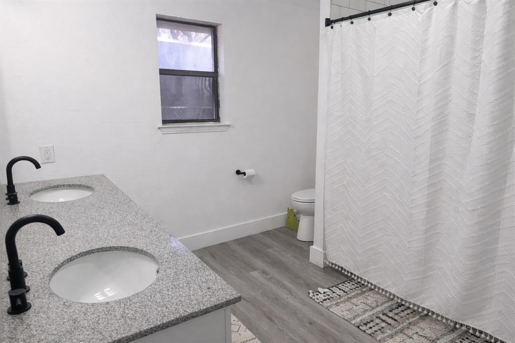 211 McAfee Street Mabank, TX 75147 - Photo 11 of 20 a bathroom with a granite countertop sink and a mirror