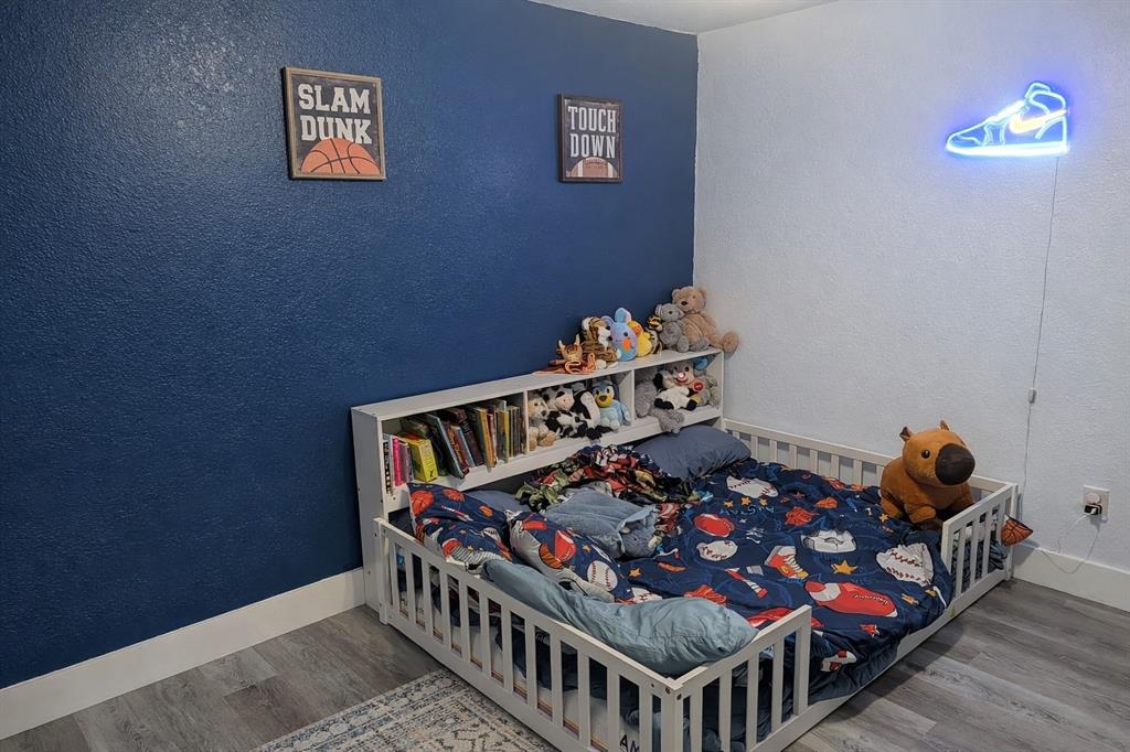 211 McAfee Street Mabank, TX 75147 - Photo 13 of 20 a bedroom with furniture and a baby crib