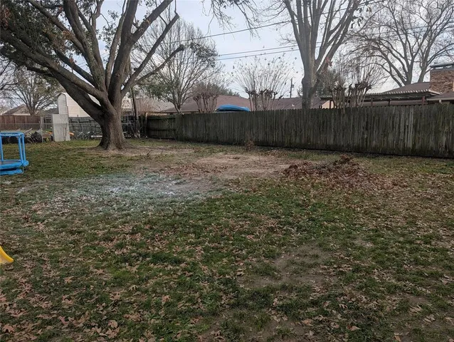 a view of a yard with wooden fence