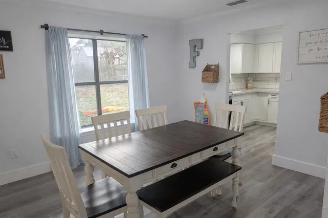 a living room with hard wood floors a table and a window