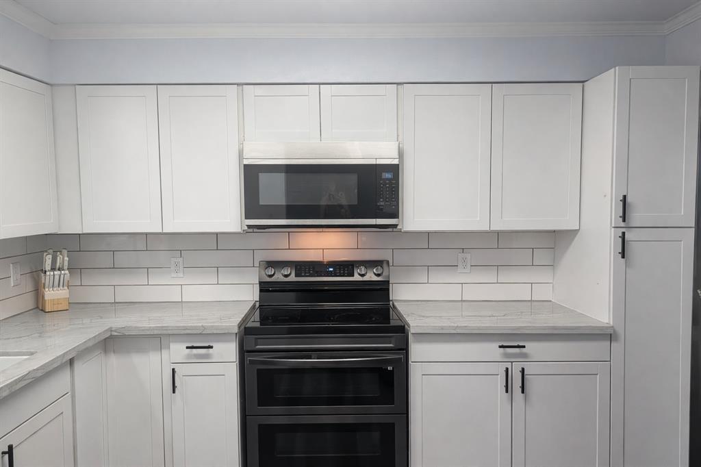 211 McAfee Street Mabank, TX 75147 - Photo 8 of 20 a kitchen with a stove and a microwave