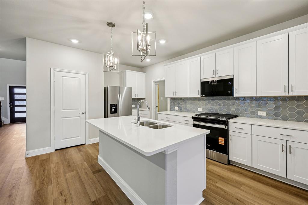 1721 Arches Road Anna, TX 75409 - Photo 14 of 39 a kitchen with stainless steel appliances a sink stove and refrigerator