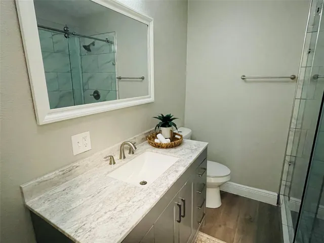 a bathroom with a sink a toilet and shower