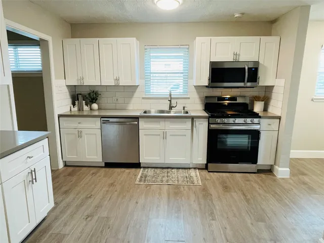 a kitchen with a sink a microwave and cabinets