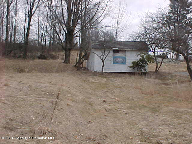 Academy Street Springville, PA 18844 - Photo 5 of 6 a view of a house with a large tree and wooden fence