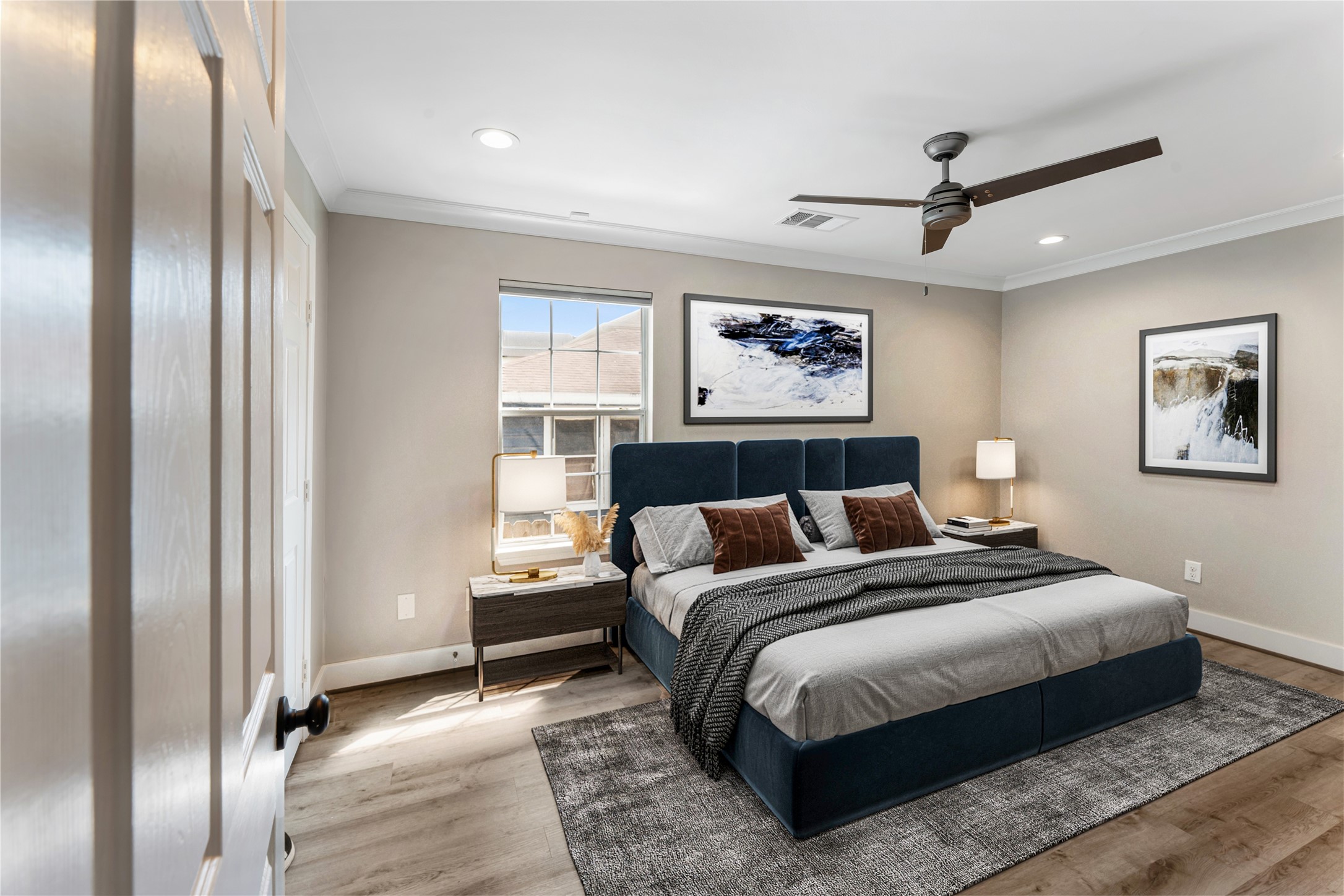 809 East 40th Street Houston, TX 77022 - Photo 14 of 27 Light-filled primary bedroom with updated flooring, neutral tones, and a ceiling fan for comfort. Clean finishes and a functional layout make this space ideal for a personal retreat. virtually staged