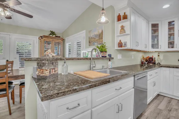 a kitchen with granite countertop a sink a stove and cabinets