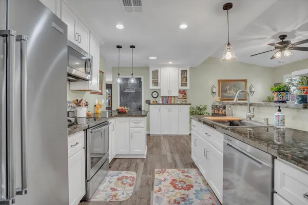 a kitchen with stainless steel appliances granite countertop a sink and a refrigerator
