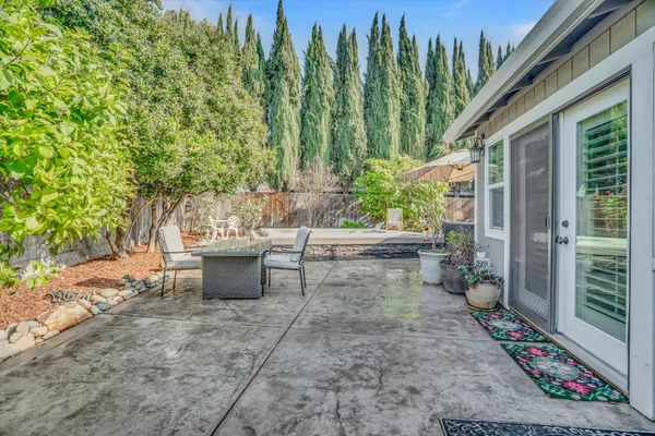 a view of a patio with table and chairs and potted plants