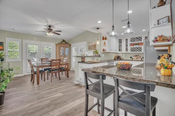 a dining room with stainless steel appliances granite countertop a dining table chairs stove and a refrigerator
