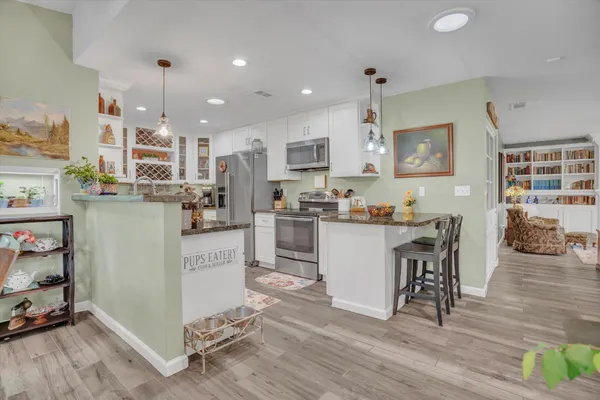 a kitchen with a table chairs refrigerator and microwave